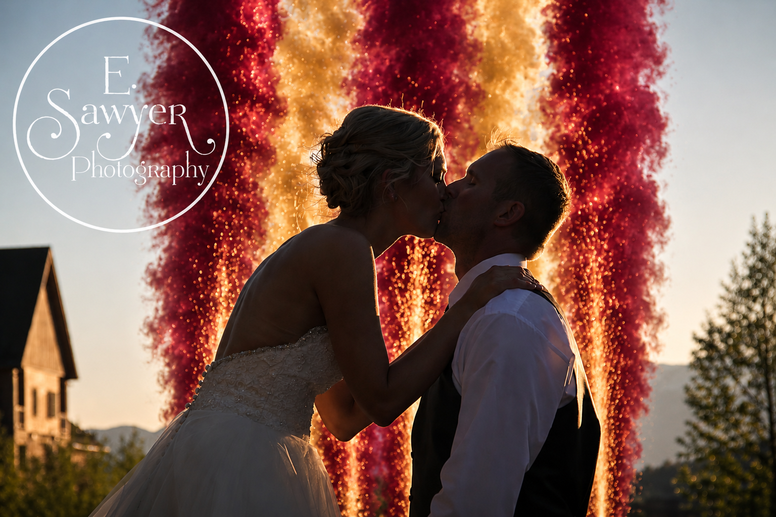 Bride and groom kissing in front of a wall of red and gold fireworks gerbs at their wedding reception