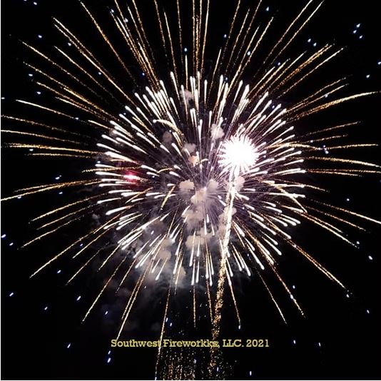 Massive gold and white multi-break finale shell filling the night sky with dense radial sparks
